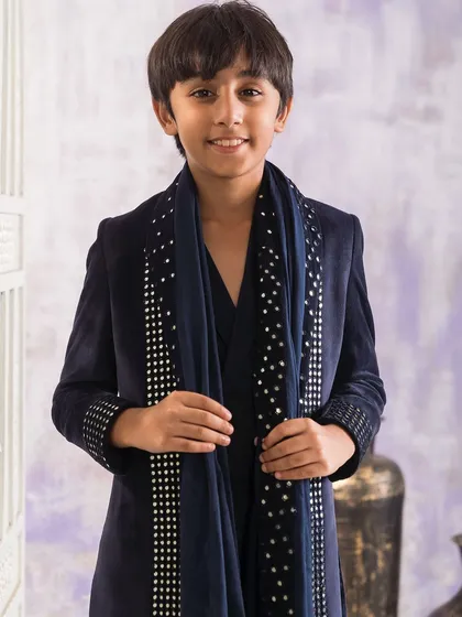 A closer look at the stud embellishments on the cuffs and dupatta of the navy blue velvet jacket. These details are all hand applied to ensure high quality.