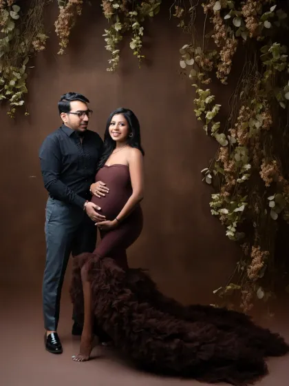 A classic couple's portrait in our rustic-themed studio. The earthy tones of the background beautifully complement their elegant dark outfits.