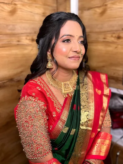 A side profile of this beautiful bride, showcasing the seamless blend of her foundation and the subtle shimmer on her cheekbones. The look is modern yet respects the traditions of a Maharashtrian engagement.