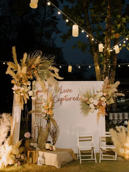 A dedicated photo spot with a "Love Captured" sign, framed by pampas grass and florals, offering guests a beautifully styled area for pictures.