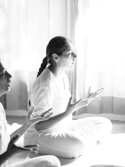 A black and white shot capturing the deep focus of a student chanting. The practice takes us beyond the physical into the realm of vibration and spirit.