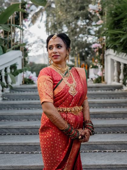 The beautiful bride Shibani on the steps of her wedding venue, looking absolutely regal in her traditional Muhurtham attire.