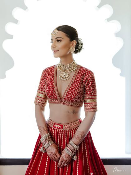 This image showcases the modern yet traditional feel of the look, with a deep V-neckline balanced by classic makeup and hair.