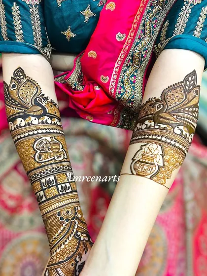 The arm details of a story-rich design, featuring traditional pots (kalash) and graceful peacock figures.