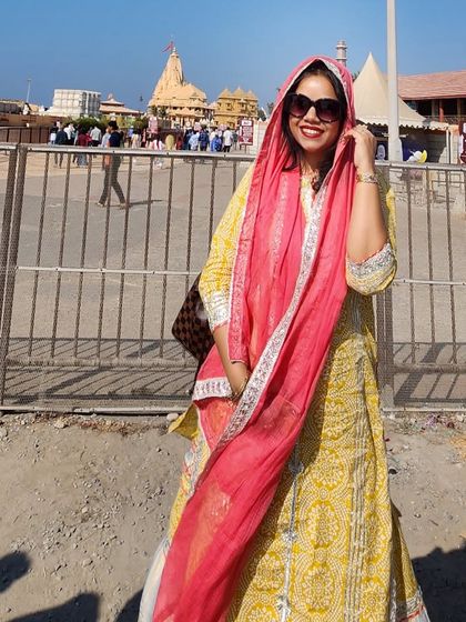 A bright yellow and white printed suit with a contrasting pink dupatta, styled for a visit to the Somnath Temple. This look is both respectful and stylish for a spiritual journey.
