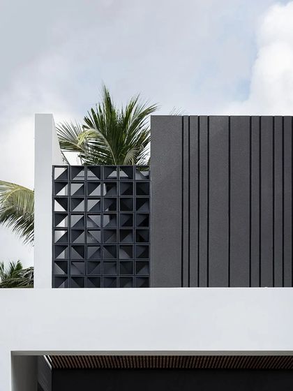 A detail of the facade, showing a custom precast concrete screen with a geometric pattern, which adds texture and privacy to the upper level.