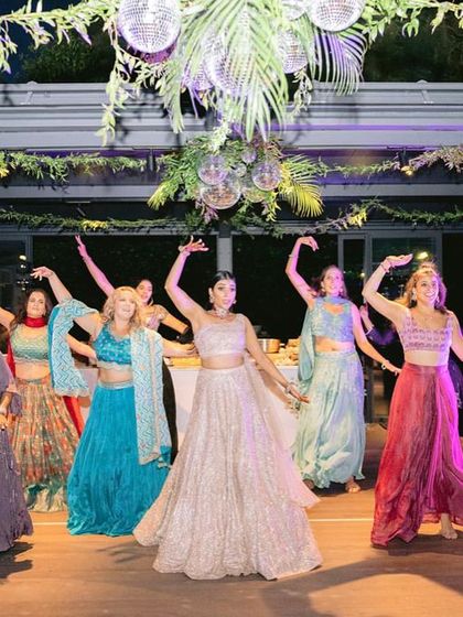 The bride and her bridesmaids in a stunning group pose during their performance at a destination wedding in Italy.