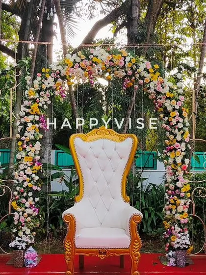 I created this grand, regal stage for an outdoor ring ceremony. The ornate throne-style chairs and a lush floral arch provide a royal setting for the couple to exchange their rings.