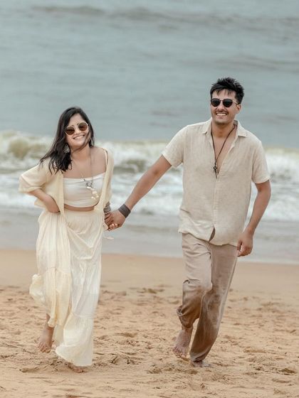A candid moment of joy, running along the shoreline in Goa. I focus on capturing these natural interactions that show your personality as a couple, making the photos feel authentic and full of life.
