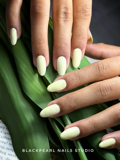 A beautiful butter yellow structured gel overlay on natural nails. This soft, creamy color gives off fresh summer vibes and showcases a clean, luxurious finish on short nails.