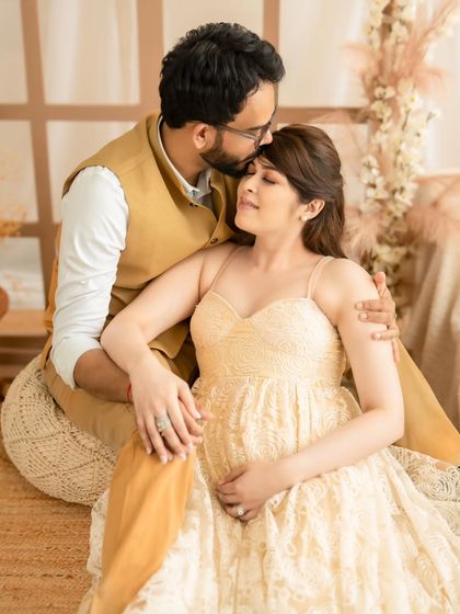 A tender moment captured in our boho studio, with the dad-to-be kissing his partner's forehead.