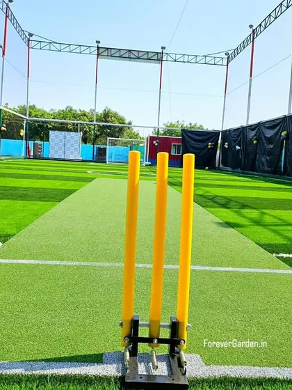 A close-up of the cricket pitch area within the larger turf, showing the specialized surface integrated seamlessly with the surrounding field.