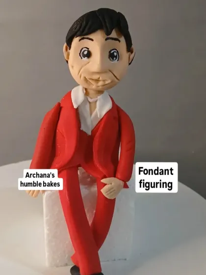 An example of a detailed fondant figurine of a man in a red suit, which can be used as a custom cake topper.