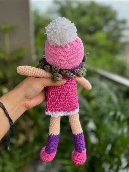The back view of our Patsy doll, showing her curly hair and pom-pom hat. Every detail is handcrafted to create a unique personality for each doll.