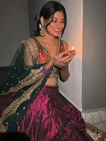 A happy moment during Diwali. The dark green dupatta with heavy gold embroidery provides a beautiful contrast to the magenta and gold of the lehenga.