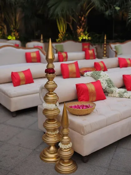 Regal elegance for a traditional wedding. We created this seating area with luxurious white sofas, vibrant red and gold cushions, and traditional golden decor pieces.