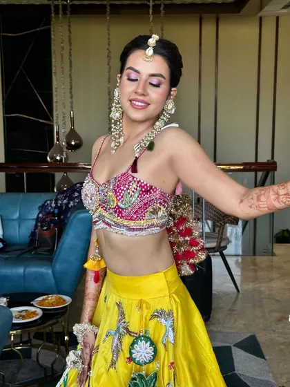 Haldi ready. I created this fun look with subtle purple eyes to complement the vibrant yellow and pink of her outfit.