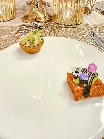 Two distinct canapés served as a pair to start the meal. One is a crisp tartlet, the other a savory bite on a fried bread base.