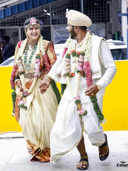 A happy, candid shot of the couple walking hand-in-hand after their Kannadiga wedding ceremony, full of joy and excitement.