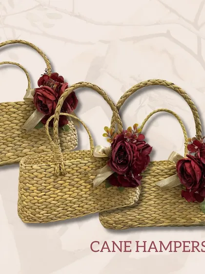 A set of cane hampers decorated with deep red roses. These eco-friendly and rustic-chic bags are perfect for creating beautiful, sustainable gift hampers.