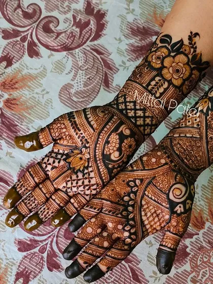 This full-hand design combines floral elements with traditional Indian patterns. The dark, solid fingertips create a beautiful contrast with the detailed work on the palms.