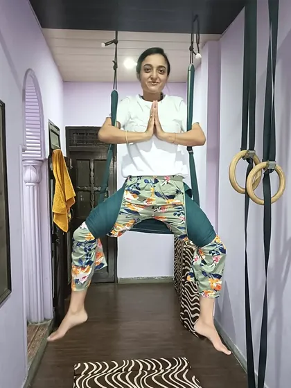 A student in a seated prayer pose in the hammock. A moment of peace and gratitude.