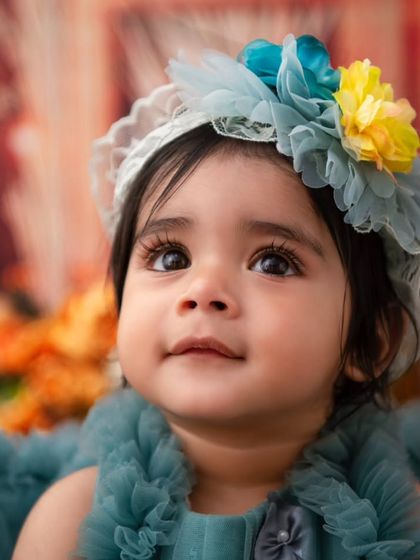 A close-up portrait of a beautiful baby girl. The soft, warm background and her stunning eyes make this a captivating image.