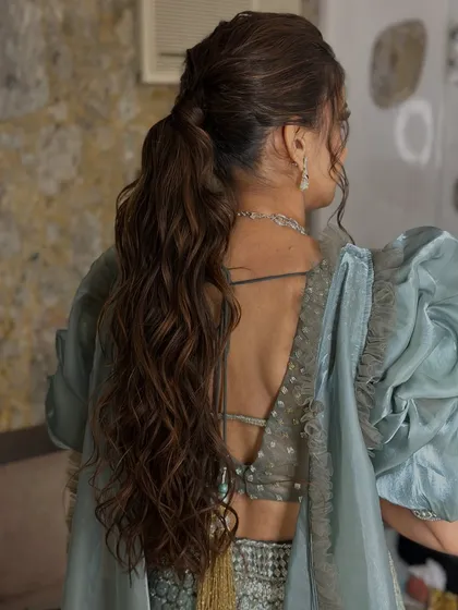 A detailed shot of the textured, wavy ponytail. A chic and modern hairstyle that is perfect for a Sangeet or reception.