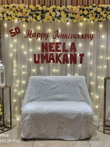 An elegant stage for a 50th wedding anniversary. We used a yellow and white floral frame, a fairy light curtain, and personalized names to create a classic look.