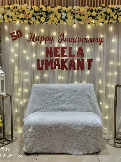 An elegant stage for a 50th wedding anniversary. We used a yellow and white floral frame, a fairy light curtain, and personalized names to create a classic look.