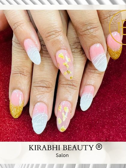 This elegant nail set features a mix of textures, including gold glitter tips, delicate gold foil flakes, and a subtle white textured design.