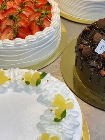 A beautiful fresh strawberry cake and a rich chocolate drip cake, side by side.