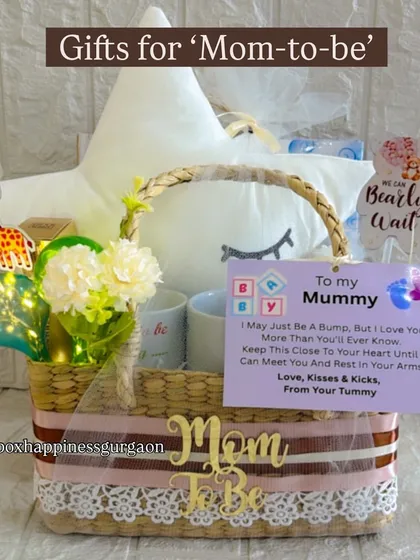 A beautifully arranged "Gifts for Mom-to-be" basket, featuring a star cushion and a sweet note from the baby bump.