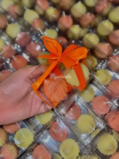 A closer look at the modak candle gift set. The clear box and bright orange ribbon make for a cheerful and festive presentation.