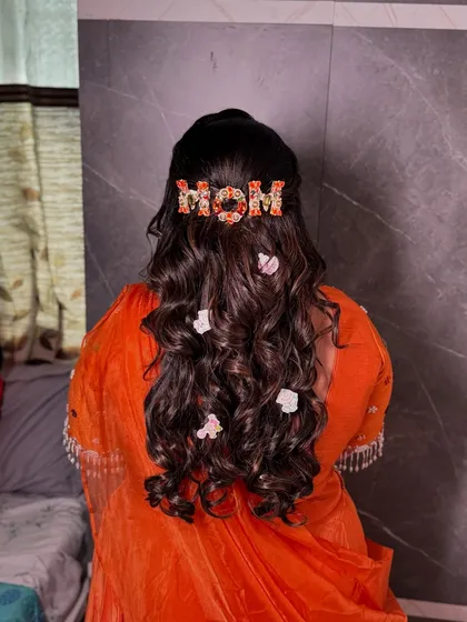 The final look of her beautiful baby shower hairstyle, with soft curls and whimsical accessories.
