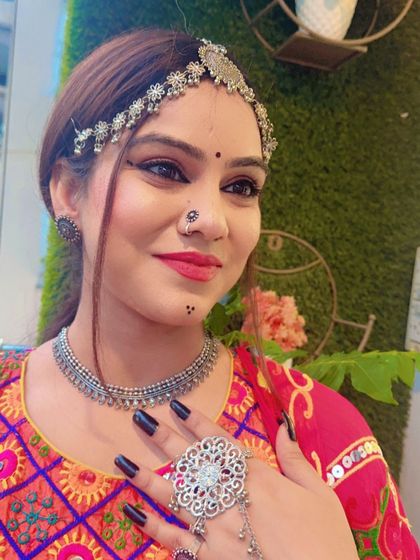A close-up of a model wearing a full set of oxidized silver jewellery, including a choker, matha patti, and hath phool. This bohemian style is perfect for Navratri.