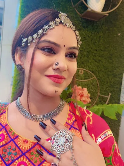A close-up of a model wearing oxidized silver jewellery, including a matha patti and choker, perfect for a Garba look.