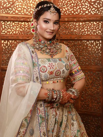 A vibrant and colorful look for a mehendi or sangeet ceremony. The multi-colored lehenga is paired with fresh, glowing makeup.