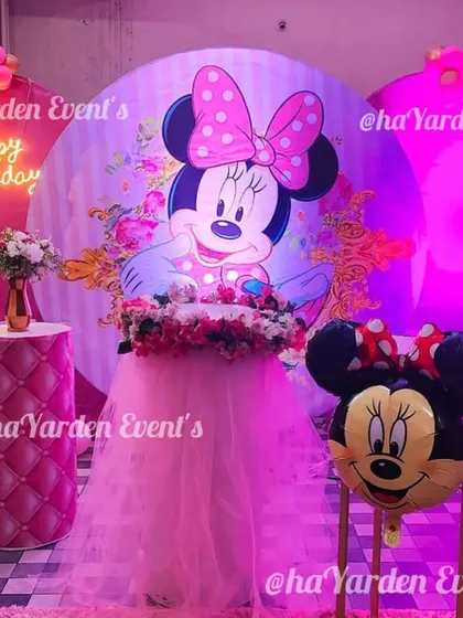 A wider view of the Minnie Mouse party, showing the full scale of the balloon decorations and the 'Happy Birthday' neon sign.