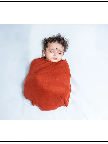 A peaceful moment from a newborn session. I ensure your baby is warm and comfortable, using soft, high-quality swaddles for these classic sleepy portraits.