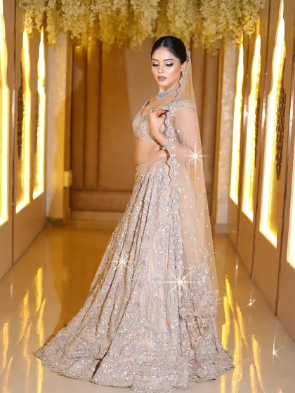 A full-length shot of the bride in her sparkling lehenga, showing how the makeup ties the whole look together.