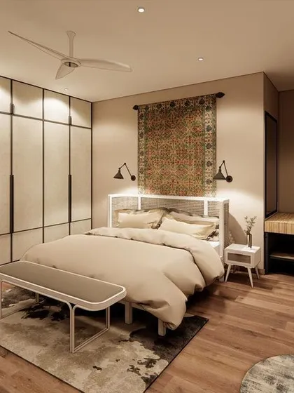 A serene bedroom designed for comfort, featuring a classic woven rug as a headboard, fabric-paneled wardrobes, and a warm, inviting color palette.