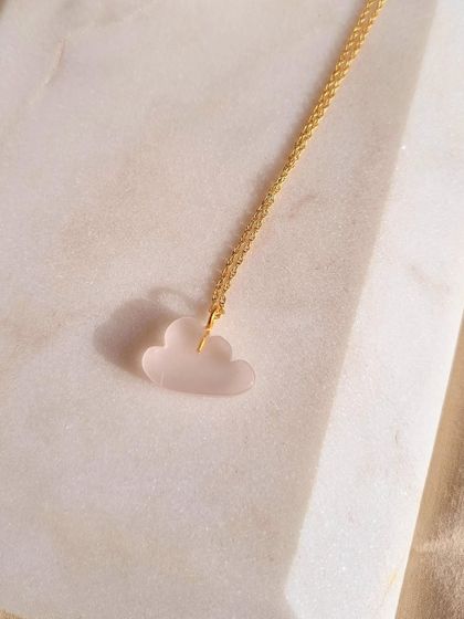 A close-up of the Rose Quartz cloud pendant. I love how the soft pink of the stone works with the whimsical cloud shape to create a piece that feels both healing and joyful.