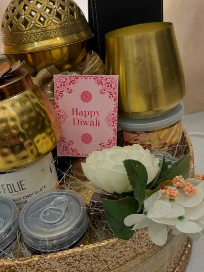 Another detail shot of the Glitterati hamper, showing the 'Happy Diwali' card nestled amongst the golden gifts and gourmet treats.