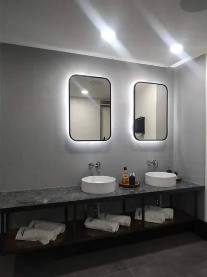 A close-up of the dual vanity in the studio's restroom. The backlighting on the mirrors provides excellent task lighting while adding a touch of sophisticated design to the space.