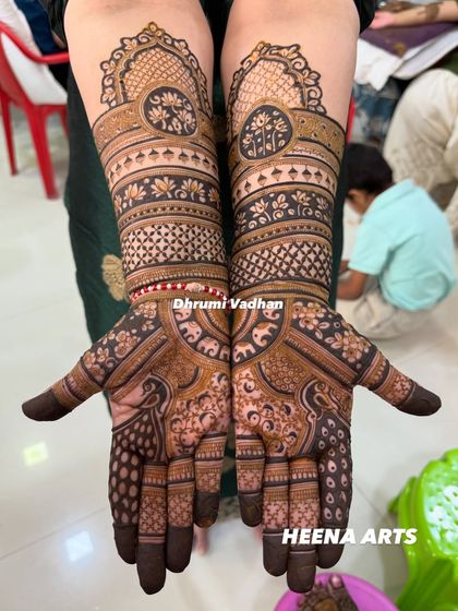 This design features bold peacock figures on the palms, with intricate bands of lotuses and geometric patterns on the arms.