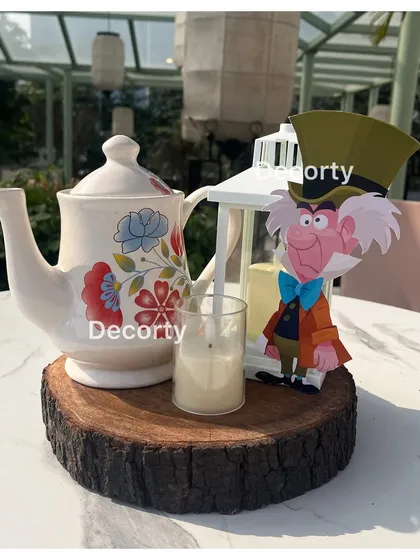 A Mad Hatter-themed centerpiece, complete with a teapot, lantern, and a character cutout.