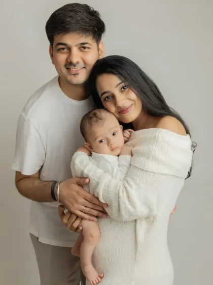 A classic first family portrait. I love the simplicity of the all-white outfits, which keeps the focus on the family's loving connection and their beautiful baby.