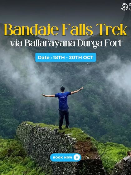 A trekker stands on a fort wall, looking out at the misty mountains on the Bandaje Falls trek.