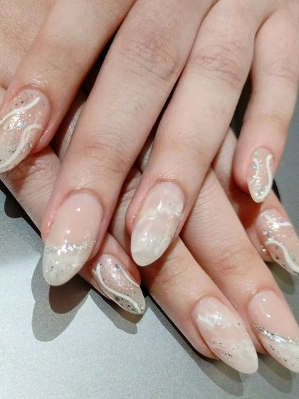 An elegant winter-themed design with a sheer, shimmery base and delicate, wavy silver glitter lines.